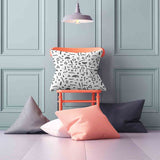 White health pillow with black shapes.