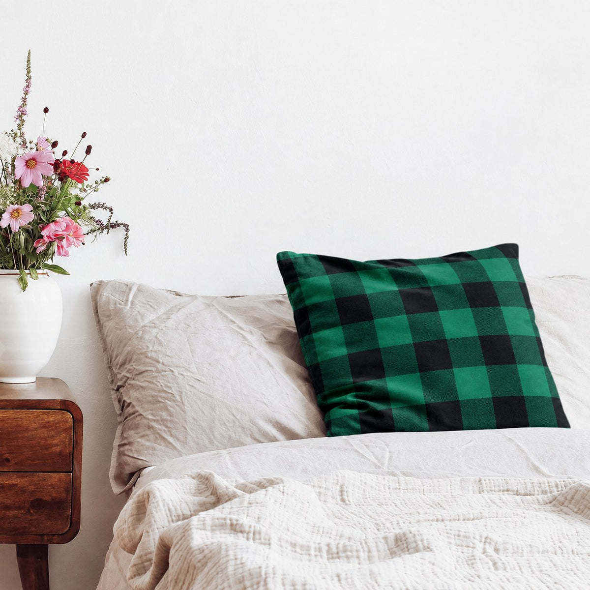 Kissen mit Flanellbezug in Grün Kariert auf einem Bett neben einem Nachttisch mit Blumen