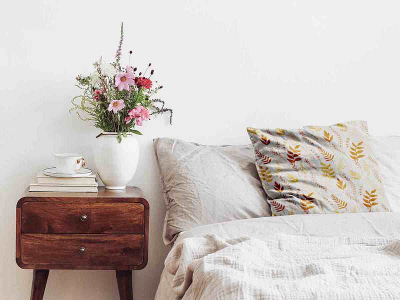 Almohada de salud blanca con ramas otoñales