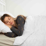Therapy blanket and bedding set, white with a delicate geometric pattern.