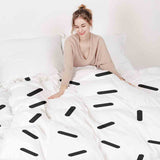 Set de ropa de cama con mantas terapéuticas y rayas negras